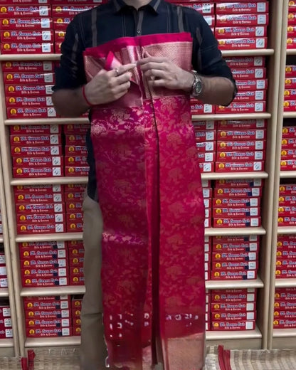 Person holding a red saree in front of shelves with red boxes.