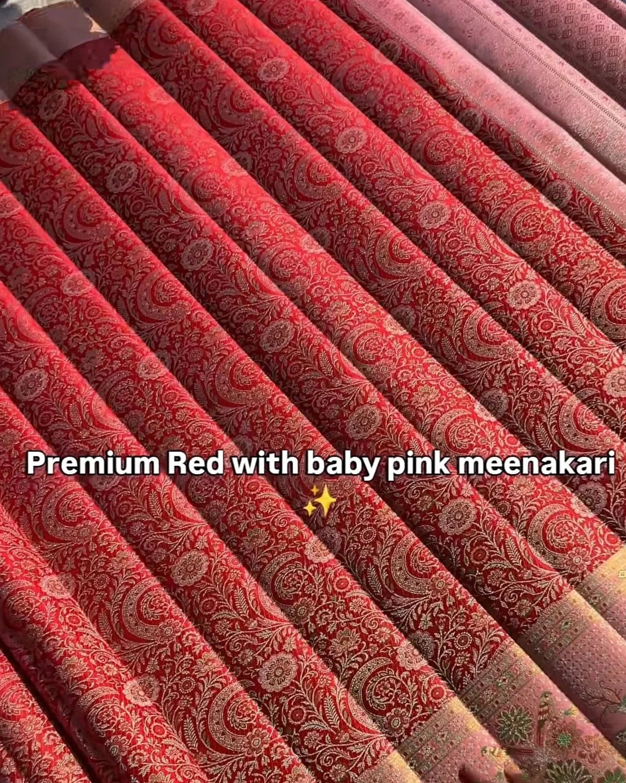 red fabric with baby pink meenakari pattern held by hands