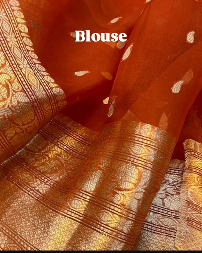 A close-up of an orange sheer organza blouse fabric with scattered small white motifs and a wide gold zari brocade border. The word 'Blouse' is overlaid in white text.